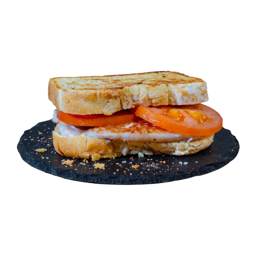 Sándwich Yogui lomo con lomo y tomate en pan de semilla de oro, servido sobre una base de pizarra; foto de producto de Yogui Burger en Torrejón de Ardoz.